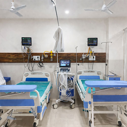 Clean hospital ward with two beds, monitors, and medical equipment.