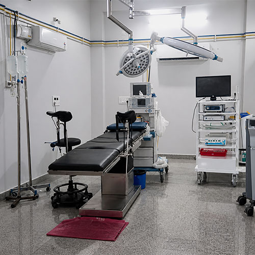 clean surgical room with an exam table, overhead lights, and medical equipment.